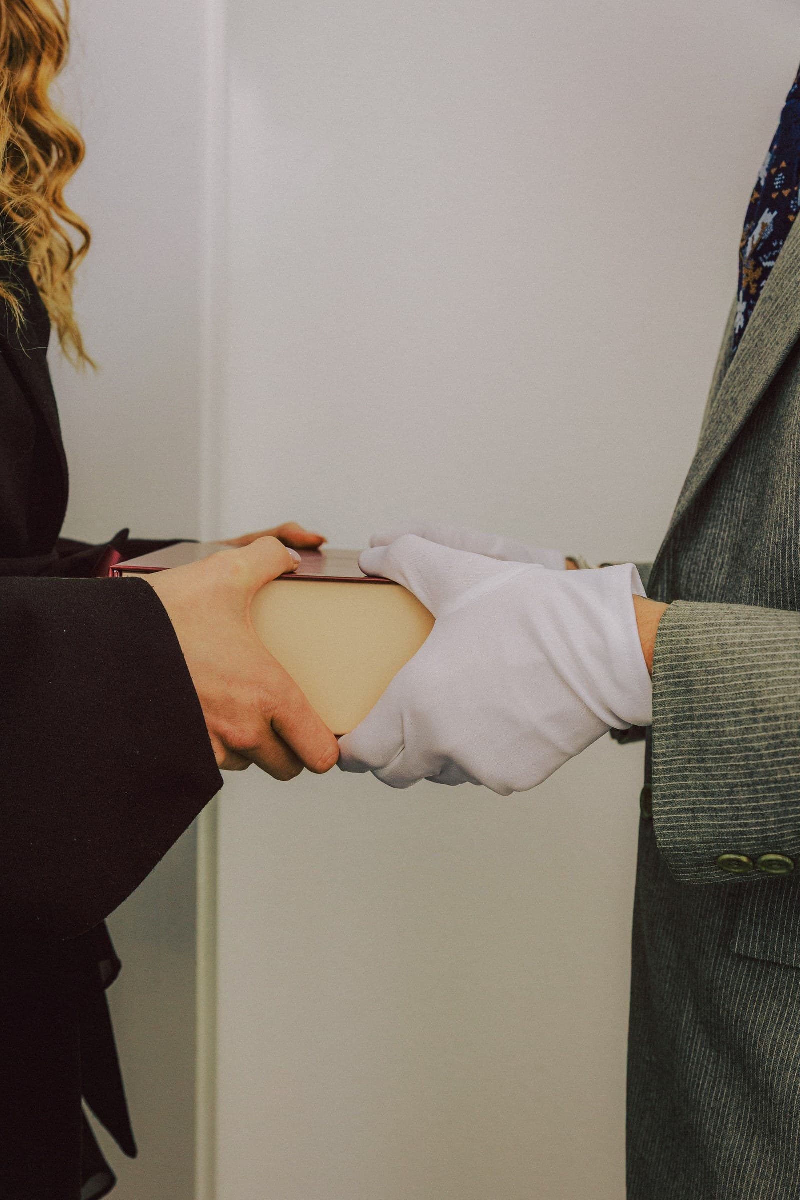 A Ring & Robe box passed from one hand to a white-gloved hand