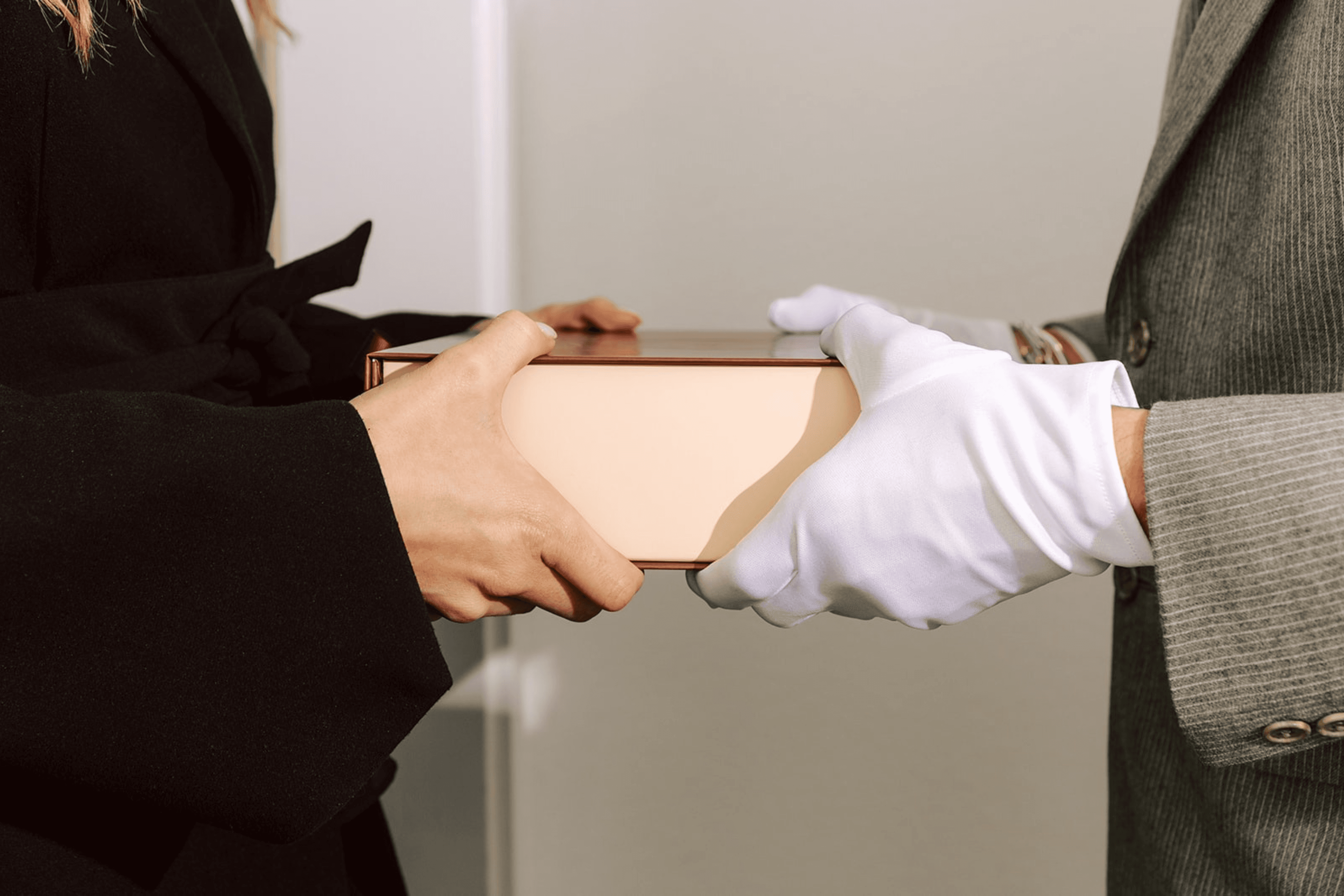 A Ring & Robe cookie box passed hand to white-gloved hand